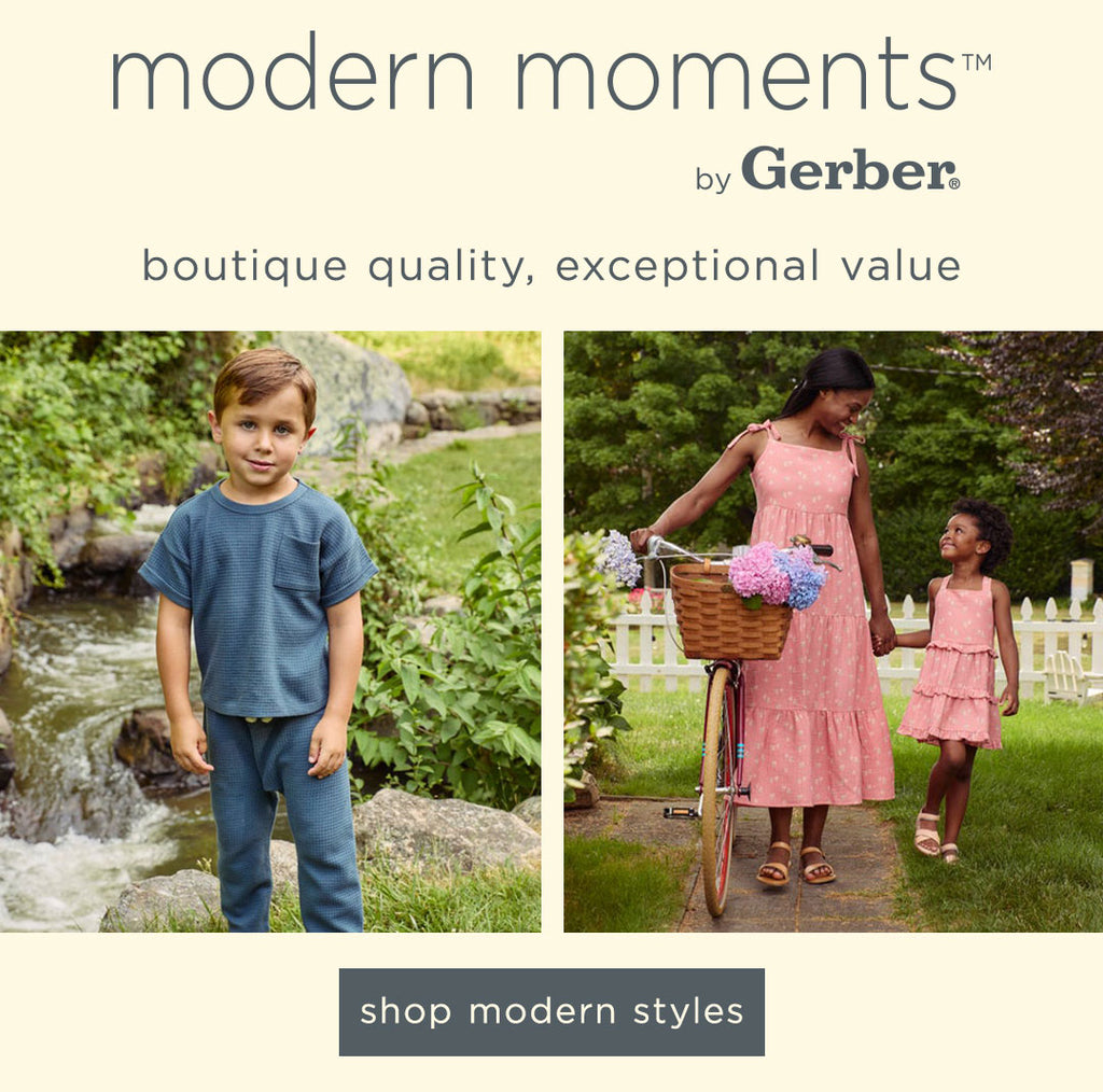 A serene modern moments™ by Gerber Childrenswear® banner featuring a boy in cozy blue loungewear by a stream and a mother and daughter in matching pink floral dresses beside a bicycle with a basket of hydrangeas, embodying boutique quality and exceptional value in spring fashion.