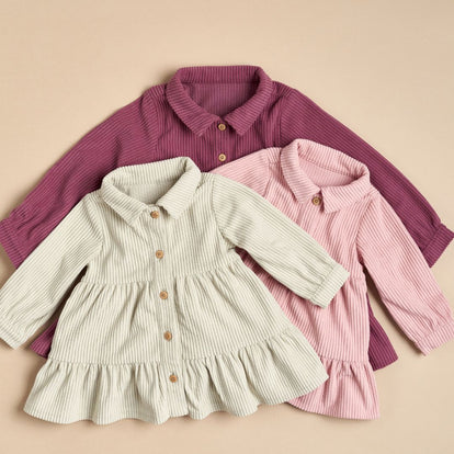  Three baby girl dresses displayed in pink, green, and purple, showcasing a variety of colors for young children's fashion